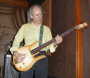 Tom plucks the strings.